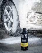Butelka PAICAR Ultra Snow Foam przy kole auta w pianie, zdjęcie producenta